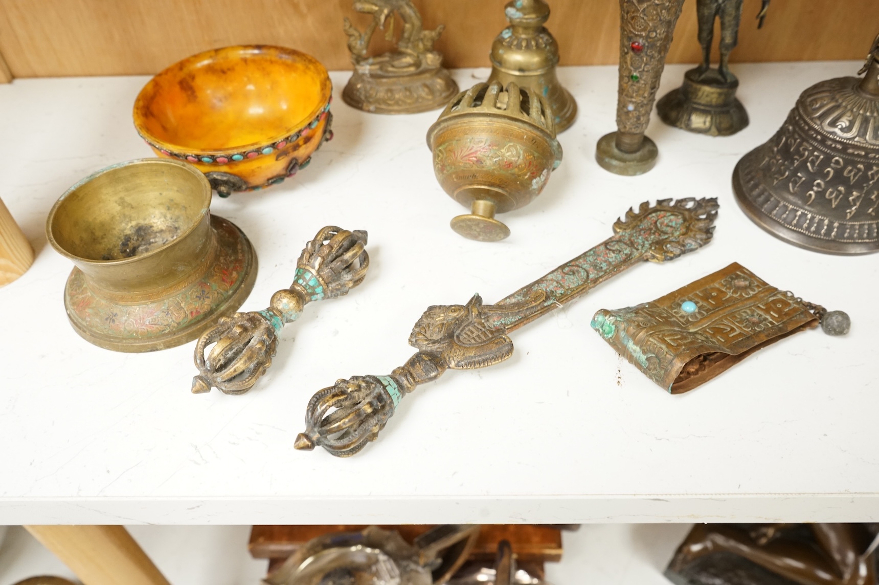 A group of Tibetan brass and mixed metal artefacts to include a brass vase with cabochon inset stones and figures of deities, largest 22cm high